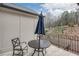 Balcony featuring a table, chair, and black metal railing overlooking mature trees at 3450 Commander Cv, Suwanee, GA 30024