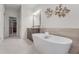 Bright bathroom showcasing a soaking tub, double vanity, and modern fixtures at 3450 Commander Cv, Suwanee, GA 30024