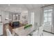 Kitchen with white cabinetry opens to a dining area with seating for six; modern lighting above at 3450 Commander Cv, Suwanee, GA 30024