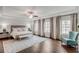 Spacious main bedroom featuring elegant paneled wall, tray ceiling, and hardwood flooring at 3450 Commander Cv, Suwanee, GA 30024