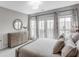 Relaxing bedroom with a queen-sized bed, light gray walls, and French doors to a private balcony at 3450 Commander Cv, Suwanee, GA 30024