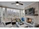 Covered patio with fireplace, TV, comfortable seating, and wooded backyard views at 3450 Commander Cv, Suwanee, GA 30024