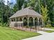 Community pavilion with ramp, stairs, black railings, and mature trees in a beautifully landscaped setting at 3450 Commander Cv, Suwanee, GA 30024
