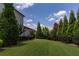 Spacious backyard with healthy, green lawn and mature trees and bordering fence line at 4430 Alister Park Dr, Cumming, GA 30040
