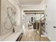 Hallway featuring artwork and a bench, leading to an open-concept living area with natural light at 4430 Alister Park Dr, Cumming, GA 30040
