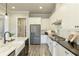 White kitchen showcases stainless steel appliances, an island with seating, and granite countertops at 4430 Alister Park Dr, Cumming, GA 30040