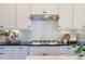 This kitchen boasts white cabinetry, granite countertops, and stainless steel gas cooktop with subway backsplash at 4430 Alister Park Dr, Cumming, GA 30040