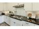 Granite countertops and subway tile backsplash add style to this kitchen with stainless steel gas cooktop at 4430 Alister Park Dr, Cumming, GA 30040