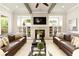 Bright living room with a stone fireplace, built-in cabinets, and comfortable leather sofas at 4430 Alister Park Dr, Cumming, GA 30040
