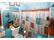 Bright bathroom with blue walls and a decorative shower curtain, toilet and vanity at 1030 Chapman Ln, Stone Mountain, GA 30088