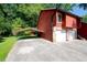 View of a carport leading to a two car garage, surrounded by green lawn at 1030 Chapman Ln, Stone Mountain, GA 30088