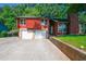 Exterior shot shows a two-car garage, carport, and stone accents at 1030 Chapman Ln, Stone Mountain, GA 30088