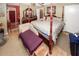 The primary bedroom has a four-poster bed, wood floors, a seating area, and lots of natural light at 1030 Chapman Ln, Stone Mountain, GA 30088