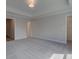 Bedroom with carpet flooring, large window, tray ceiling, and doorway to a closet at 1976 Deco Dr, Kennesaw, GA 30144
