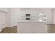 Modern white kitchen with a large island, stainless steel appliances, and a bright, open layout at 205 Silver Moon Dr, Loganville, GA 30052