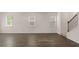 Open living space features wood floors, lots of light from three windows, white trim, and a staircase at 205 Silver Moon Dr, Loganville, GA 30052