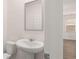 Powder room with a white sink and toilet, mirror, and view into the living space at 205 Silver Moon Dr, Loganville, GA 30052