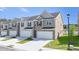 Attractive townhome complex with brick and siding exteriors, showcasing attached garages and landscaped front yards at 205 Silver Moon Dr, Loganville, GA 30052