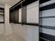 Spacious walk-in closet boasts shelving and clothing rods for ample storage with neutral color palette at 1983 Deco Dr, Kennesaw, GA 30144