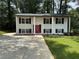 Lovely two-story home with white brick, black shutters, and a vibrant red front door at 2764 Ocean Valley Dr, Atlanta, GA 30349