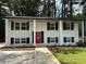 Charming two-story home with white brick, black shutters, and a vibrant red front door at 2764 Ocean Valley Dr, Atlanta, GA 30349