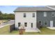 View of the back of the home with two stories, neutral colors, and a small patio at 6381 Rosetta Drive # 83, South Fulton, GA 30331