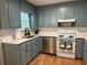 View of the kitchen with stainless steel appliances, blue cabinets, and stylish backsplash at 10 Vaughan Ne Ct, Cartersville, GA 30121