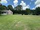 Spacious lawn with lush green grass and mature trees, partially enclosed by a white picket fence at 10 Vaughan Ne Ct, Cartersville, GA 30121