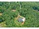 Expansive aerial view of a secluded estate surrounded by lush greenery and a winding driveway at 2100 Mountain Cove Ct, Woodstock, GA 30188