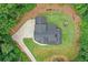 Aerial view of the black home showing the circle drive and surrounding landscape at 2100 Mountain Cove Ct, Woodstock, GA 30188