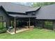 Beautiful view of a black home with a covered patio and an expansive lawn at 2100 Mountain Cove Ct, Woodstock, GA 30188