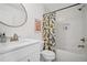 Bright bathroom with white tile, patterned shower curtain, and modern fixtures at 2100 Mountain Cove Ct, Woodstock, GA 30188