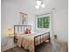 Cozy bedroom with a metal frame bed, neutral decor, and a view of the outdoors at 2100 Mountain Cove Ct, Woodstock, GA 30188