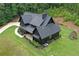 Stunning dark modern farmhouse with inviting front porch, lush lawn and beautiful wooded backdrop at 2100 Mountain Cove Ct, Woodstock, GA 30188