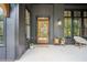 Stylish front porch with a modern black brick wall, wood trim, and inviting outdoor seating at 2100 Mountain Cove Ct, Woodstock, GA 30188
