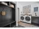 Functional laundry room with modern washer and dryer, storage, and black slate floors at 2100 Mountain Cove Ct, Woodstock, GA 30188