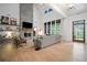 Bright living room with high ceilings, a modern fireplace, and large windows showcasing the outdoor view at 2100 Mountain Cove Ct, Woodstock, GA 30188