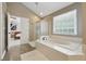 Bright primary bathroom featuring a shower, soaking tub, and vanity area at 775 Gran Heritage Way, Dacula, GA 30019