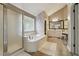 Bright primary bathroom featuring a shower, soaking tub, and vanity area at 775 Gran Heritage Way, Dacula, GA 30019