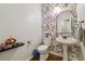 Powder room with floral wallpaper, pedestal sink, hardwood floors, and modern fixtures at 775 Gran Heritage Way, Dacula, GA 30019