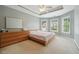 Primary bedroom featuring a tray ceiling, triple windows, and neutral carpet at 775 Gran Heritage Way, Dacula, GA 30019