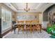 Inviting dining room featuring tray ceilings, hardwood floors, and a stylish chandelier above a table for six at 775 Gran Heritage Way, Dacula, GA 30019