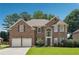 Charming two-story brick home featuring a manicured lawn, two-car garage, and large arched entryway at 775 Gran Heritage Way, Dacula, GA 30019