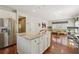 Bright kitchen features white cabinets, stainless steel appliances, and center island with granite countertops at 775 Gran Heritage Way, Dacula, GA 30019