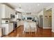 Bright kitchen features white cabinets, stainless steel appliances, and center island with granite countertops at 775 Gran Heritage Way, Dacula, GA 30019