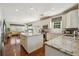 Bright kitchen features white cabinets, stainless steel appliances, and center island with granite countertops at 775 Gran Heritage Way, Dacula, GA 30019