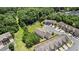 Aerial view of community with townhomes, parking lots and trees at 173 Oakland Hills Way, Lawrenceville, GA 30044