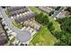 Aerial view of townhomes, street parking, and grass lots at 173 Oakland Hills Way, Lawrenceville, GA 30044