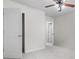 Neutral bedroom with door, carpeted flooring, ceiling fan, and an adjacent closet at 173 Oakland Hills Way, Lawrenceville, GA 30044