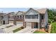 Street view showcasing townhome exteriors, driveways, and neat landscaping at 173 Oakland Hills Way, Lawrenceville, GA 30044